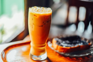 Büyük bardakta buzlu kahve ya da kafe latte koyu ahşap arka planda fotokopi alanı ile birlikte.