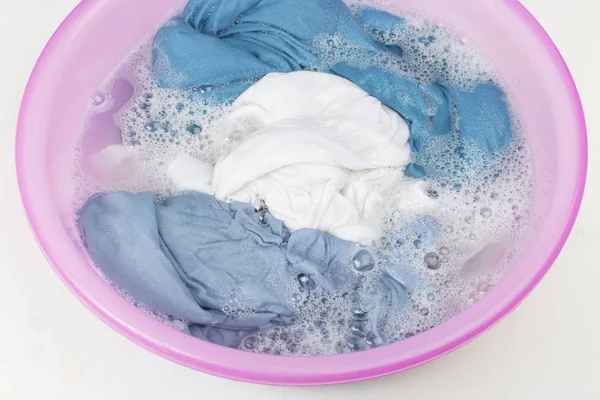 Vestiti bianchi e blu lavati con lavabo con bolle di sapone, primo piano — Foto Stock