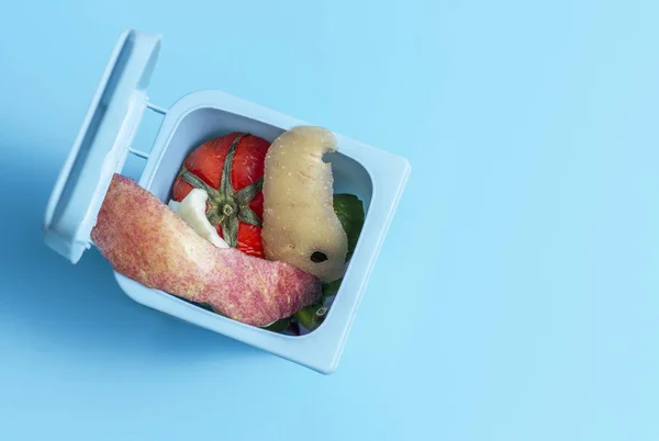 Papierkorb mit Lebensmittelabfällen drinnen auf blauem Hintergrund von oben, Kopierraum — Stockfoto