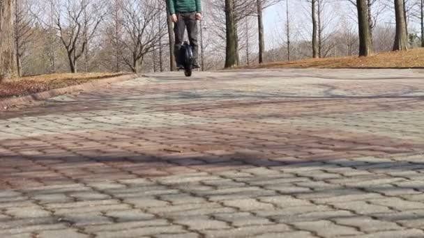 한 남자가 시립 공원에서 전기 자전거를 타고 있다. — 비디오