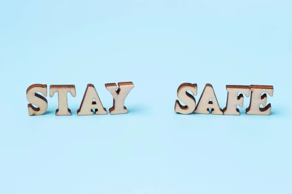 The inscription stay home in wooden letters on blue background. — Stock Photo, Image