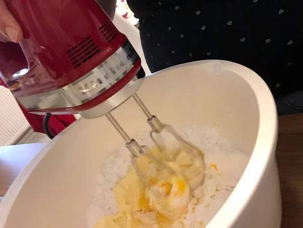 a mixer is shaking the dough  for the cake