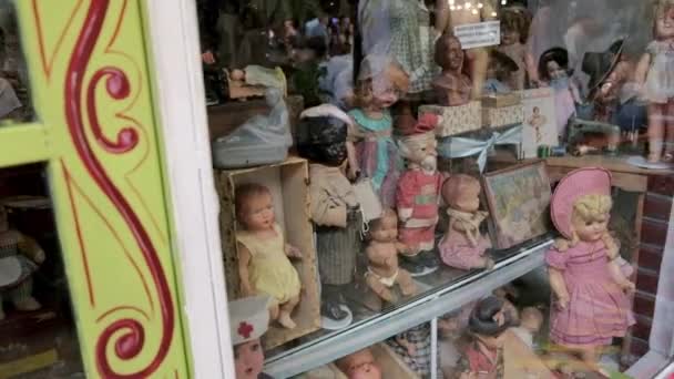 Muñecas vintage antiguas en exhibición en la Feria de San Telmo, un famoso mercado de pulgas. DOLLY izquierda — Vídeo de stock