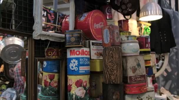 Venta de latas viejas amontonadas en una tienda de pulgas en la Feria de San Telmo. TILT abajo — Vídeo de stock