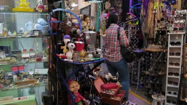 Imagen panorámica de una mujer mirando antigüedades en una tienda de pulgas en la Feria de San Telmo — Vídeo de stock