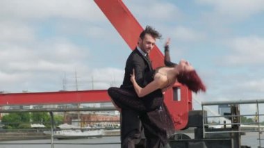 Seksi kadın dansçı partnerle dans ederken müstehcen hareketlerle eğiliyor.