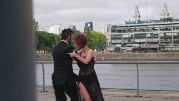 Két táncpartner, akik tangóznak Puerto Madero kikötőjében. — Stock videók