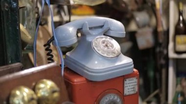Bir bit dükkanında satılık mavi vintage çevirmeli telefonun Dolly sağ çekimi