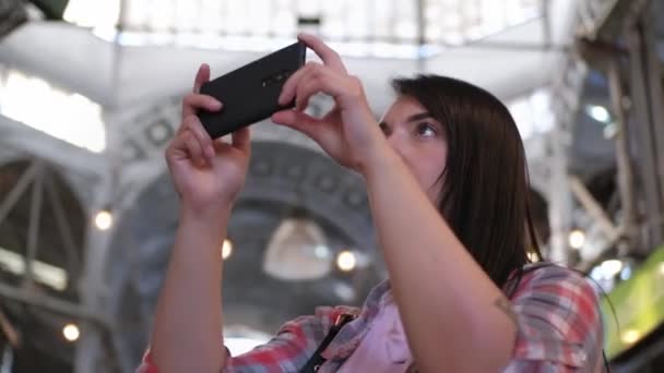 Close up shot of a pretty woman taking photos in a food market — Stock Video