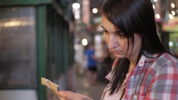 Közelkép egy fiatal nőről, aki papírmunkákat néz a piacon. — Stock videók