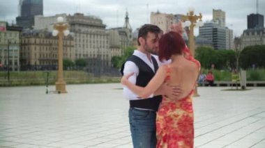 İki yakışıklı tango dansçısı Puerto Madero meydanında gösteri yapıyor.