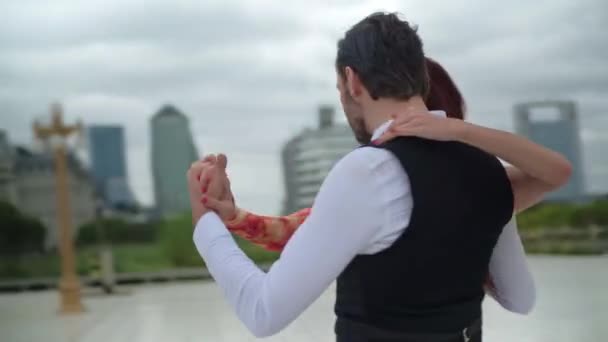 Orbitális felvétel két tangó táncosról, akik táncolás közben pörögnek és fogják egymás kezét. — Stock videók