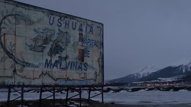 Vista da placa velha do sinal a Ushuaia pelo lado da estrada na noite atrasada — Vídeo de Stock