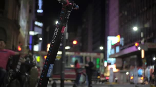 Movimiento lento de un scooter eléctrico de alquiler estacionado en una concurrida avenida, Buenos Aires — Vídeo de stock