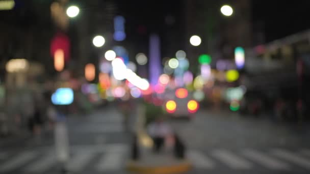 Perchero de enfoque que revela a la gente caminando por la avenida Corrientes por la noche — Vídeos de Stock