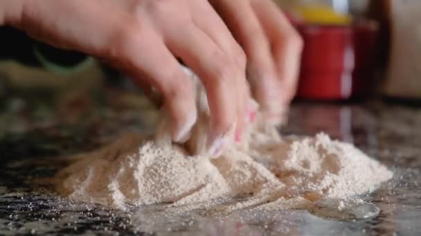 Manos de mujer mezclando un huevo con harina de trigo integral en la encimera — Vídeos de Stock