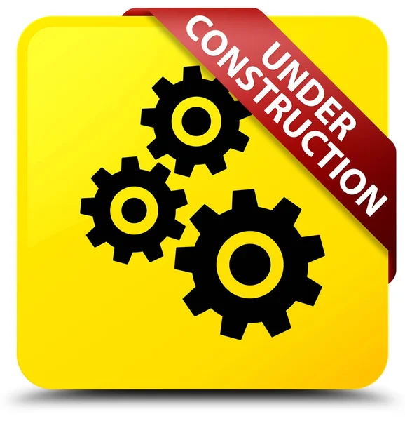 Bajo construcción (icono de engranajes) botón cuadrado amarillo cinta roja — Foto de Stock