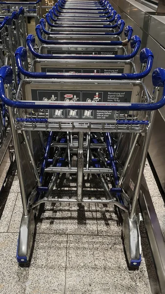 Frankfurt, Alemania, 12 26 2019. Alineados carros de equipaje vacíos en el aeropuerto de Frankfurt. La infraestructura para la comodidad de los pasajeros — Foto de Stock