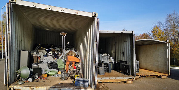Крупный план контейнеров крупногабаритной мусоросборной станции в Германии. Сортировка мусора: электрооборудование, телевизор
