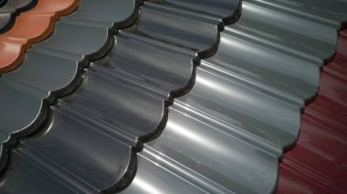 Çatı gerçekçi görünecektir. Çapraz olarak sokak tozuyla kaplanmış çeşitli renkte çeşitli fayanslar içeren birkaç sıra plastik çatı. İnşaat malzemeleri mağazasının açık hava gösterisi.