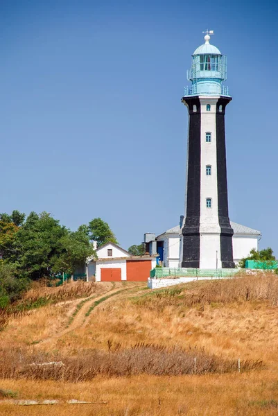 Leuchtturm-Suchscheinwerfer strahlen nachts durch die Meeresluft. Seelandschaft bei Sonnenuntergang — Stockfoto