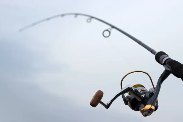 Hand met spinnen en haspel op de avond zomer lake — Stockfoto