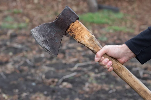 Ein Mann hält eine Axt in der Hand vor schwarzem Hintergrund — Stockfoto