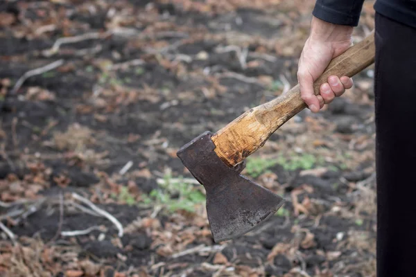 Ein Mann hält eine Axt in der Hand vor schwarzem Hintergrund — Stockfoto