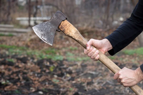 Ein Mann hält eine Axt in der Hand vor schwarzem Hintergrund — Stockfoto