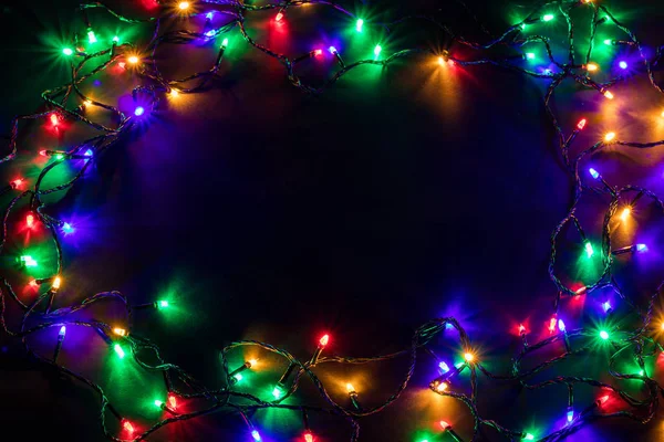 Sfondo natalizio con luci e spazio di testo libero. Luci di Natale confine. Luci di Natale colorate luminose su sfondo nero. Capodanno. Natale. Arredamento. Ghirlanda. — Foto Stock