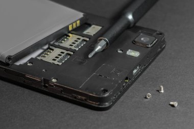 Akıllı telefonu tamir etmek, tornavidayla sökülmüş telefonu tamir etmek.