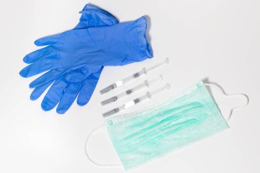 Mavi arka planda tıbbi hayat. Şırınga, tıbbi maske. Minimalizm.