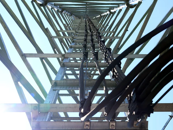 The telephone tower with antenna. View from bottom to top. Sky is background.