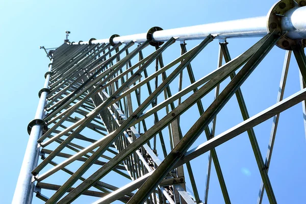 The telephone tower with antenna. View from bottom to top. Sky is background.