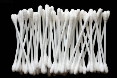 Beyaz pamuk tomurcukları siyah arka planda üst üste dizilmiştir..