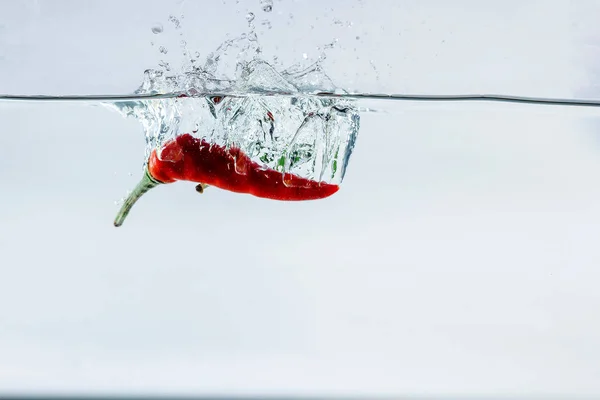 Röd Chili Vatten Stänk Solerad Vit Bakgrund — Stockfoto