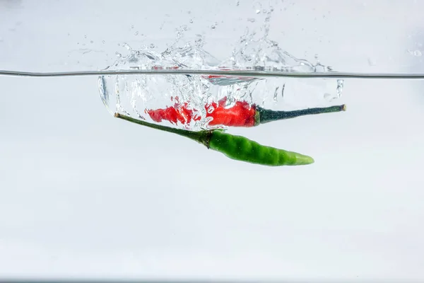 Röd Chili Vatten Stänk Solerad Vit Bakgrund — Stockfoto