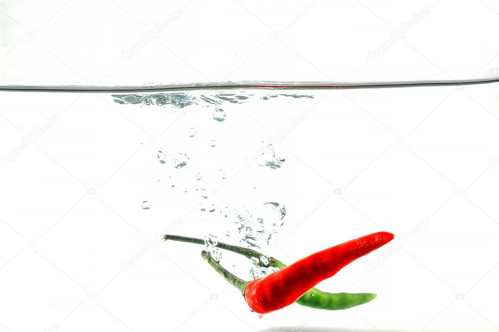 Red chilli, water splashes, solated on a white background