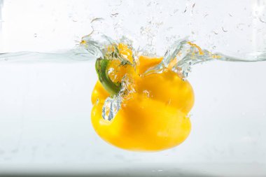 Suda tatlı biber, beyaz arka planda sarı tatlı biber. Tatlı biberler bir tür biberdir. Baharatlı değil