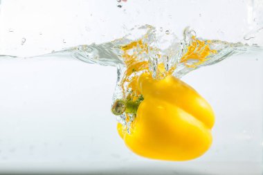 Suda tatlı biber, beyaz arka planda sarı tatlı biber. Tatlı biberler bir tür biberdir. Baharatlı değil