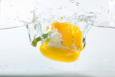 Suda tatlı biber, beyaz arka planda sarı tatlı biber. Tatlı biberler bir tür biberdir. Baharatlı değil