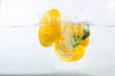 Suda tatlı biber, beyaz arka planda sarı tatlı biber. Tatlı biberler bir tür biberdir. Baharatlı değil