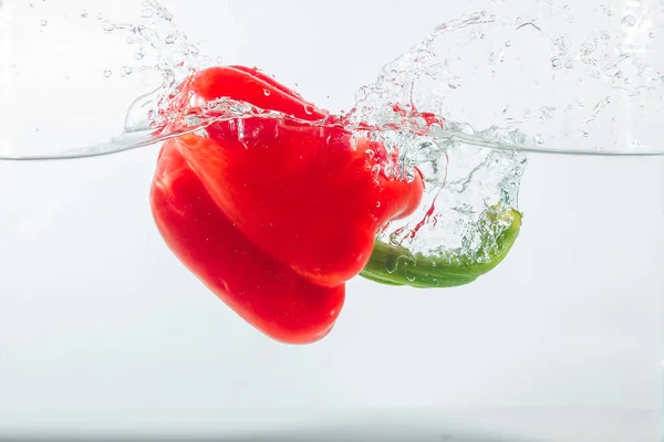 Sweet pepper in water splashes, red sweet pepper on a white background. Sweet peppers are a type of pepper. Not spicy