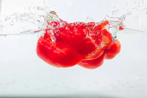 Sweet pepper in water splashes, red sweet pepper on a white background. Sweet peppers are a type of pepper. Not spicy