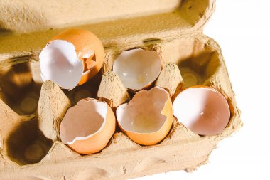 Kırık yumurta beyaz arka planda izole edilmiş, yumurtanın kabuğu kırılmış.