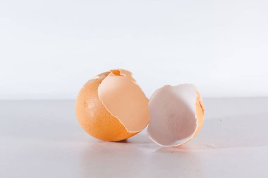 Kırık yumurta beyaz arka planda izole edilmiş, yumurtanın kabuğu kırılmış.
