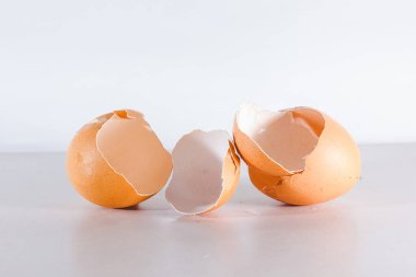 Kırık yumurta beyaz arka planda izole edilmiş, yumurtanın kabuğu kırılmış.
