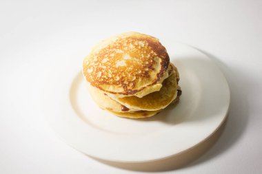 Krepler beyaz bir tabağa istiflenmiş. Beyaz bir arkaplanda