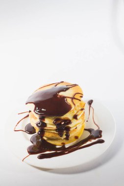 Beyaz bir tabağa istiflenmiş gözlemeler çikolatayla kaplıdır..