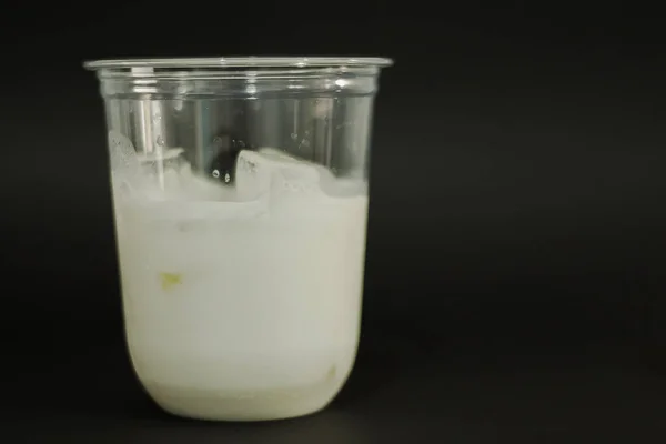 Leche Cubitos Hielo Vaso Plástico Sobre Fondo Negro — Foto de Stock